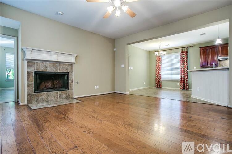 A living room with a fireplace and wood flooring.