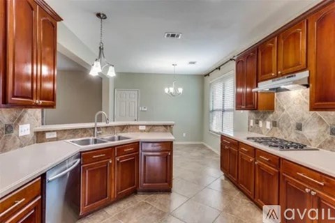 A kitchen with wooden cabinets and a marble backsplash is available.