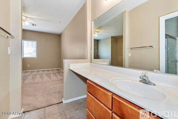 A bathroom with a sink, mirror, and wooden cabinets.