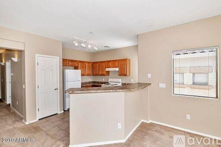 A kitchen with a white refrigerator and wooden cabinets.