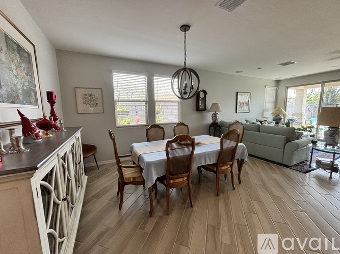 A dining room with a table set for six and a couch.