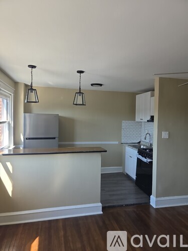 A kitchen with a refrigerator, cabinets, and a countertop.