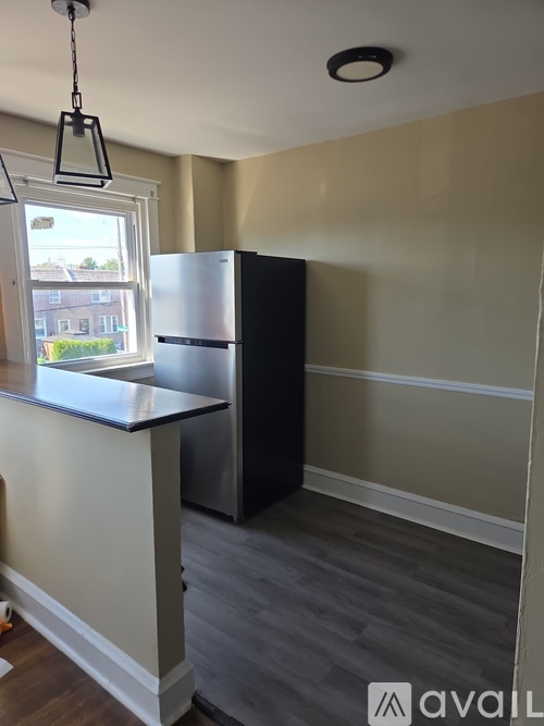 A kitchen with a black fridge and a white counter.