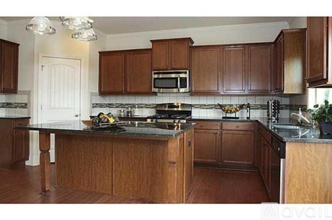 A kitchen with wooden cabinets and a black countertop.