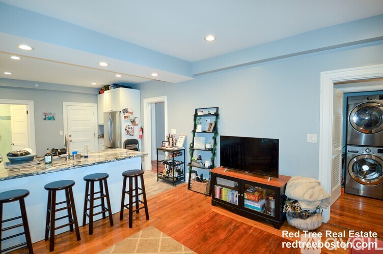 A kitchen with blue walls and wooden floors.