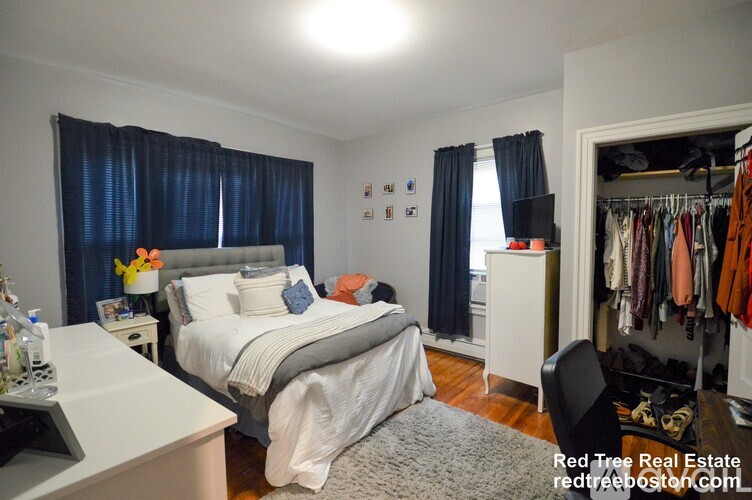 A bedroom with a bed, nightstand, and wardrobe.