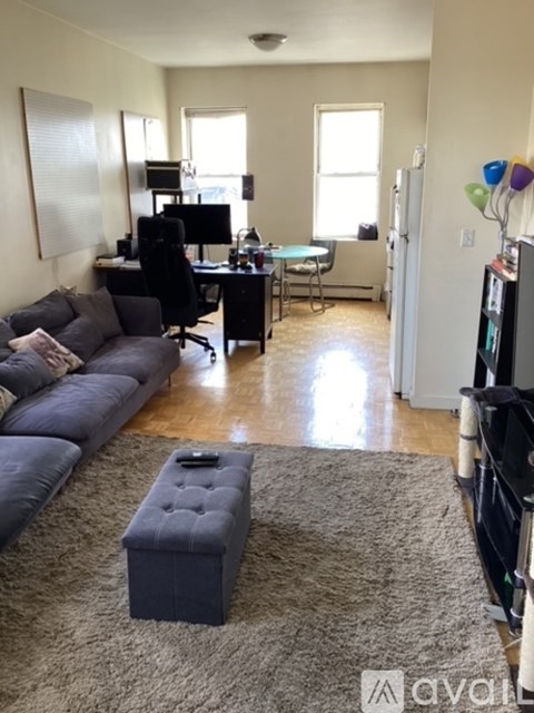 A living room with a grey couch and a black chair.