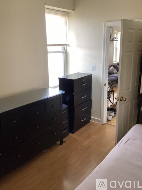 A bedroom with a bed, dresser, and a window.