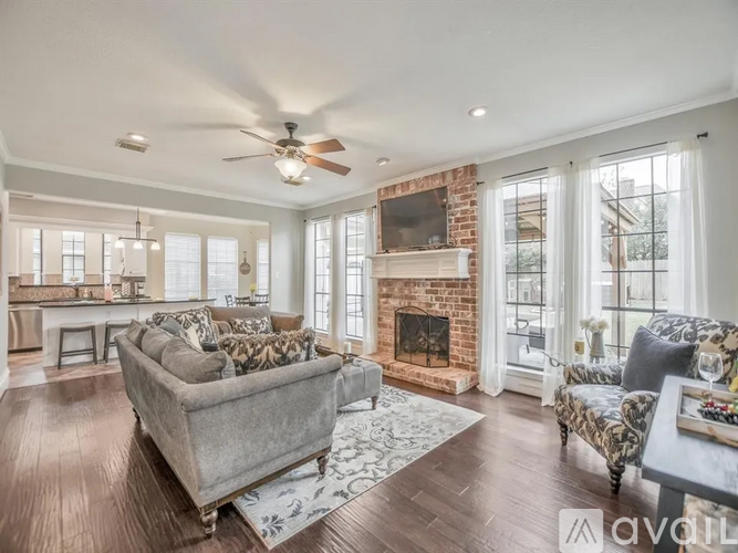 A living room with a grey couch and a fireplace.