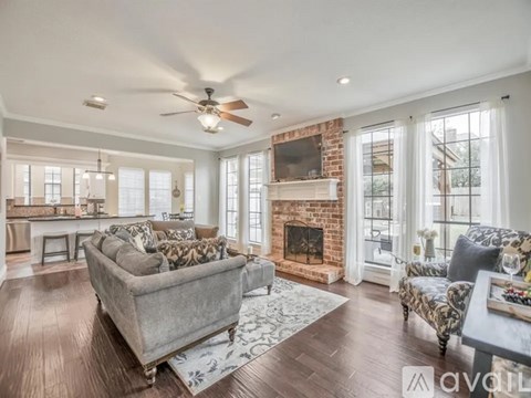 A living room with a grey couch and a fireplace.