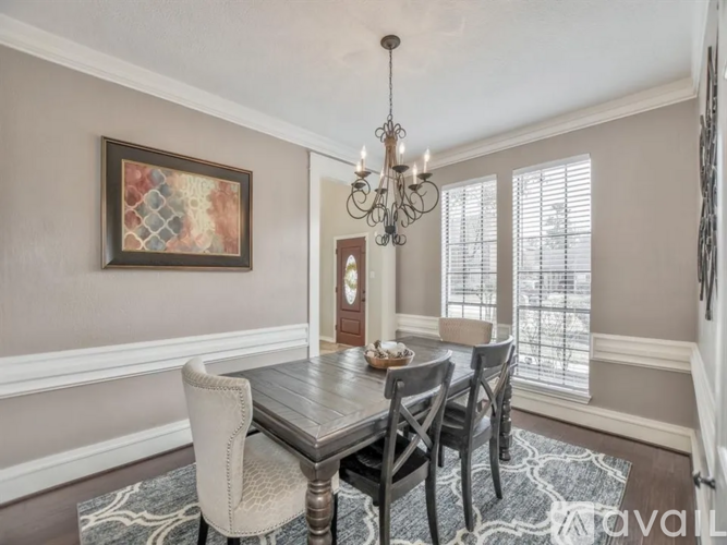 A dining room with a wooden table and chairs.