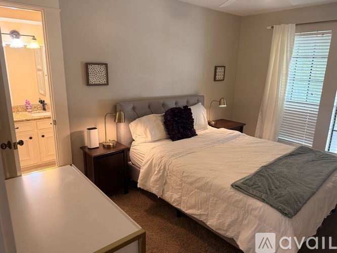 A bedroom with a bed, nightstand, and window.