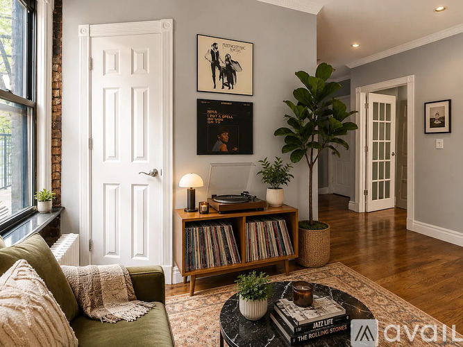 A living room with a green couch, a coffee table, a bookshelf, and a plant.