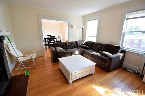 A living room with a white coffee table and brown couches.