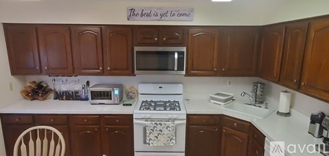 A kitchen with brown cabinets and a white stove top oven.