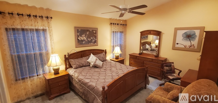 A bedroom with a bed, dresser, and mirror.