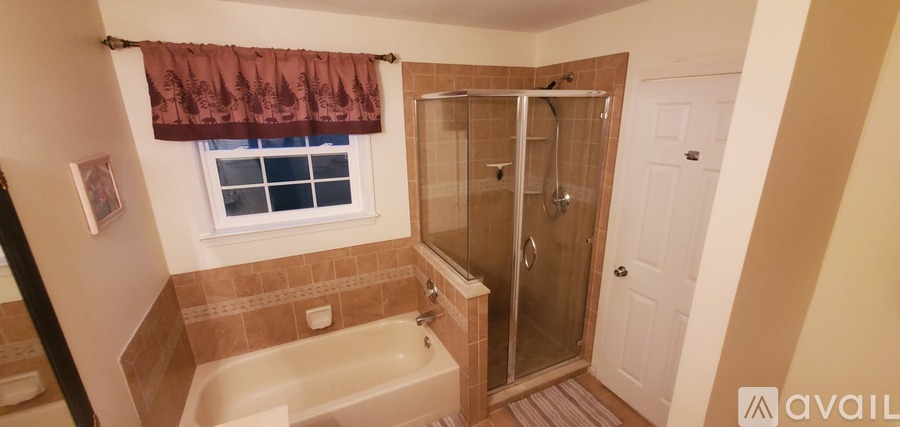A bathroom with a tub, shower, and window.