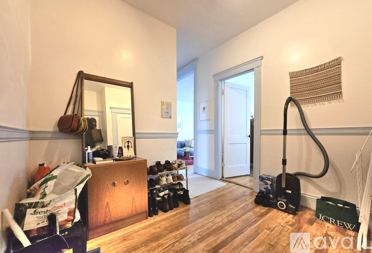 A room with a vacuum cleaner and a mirror on the wall.