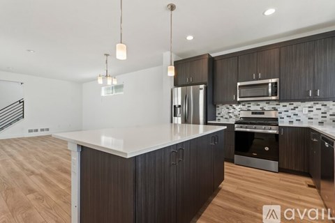A modern kitchen with dark wood cabinets and a white island.