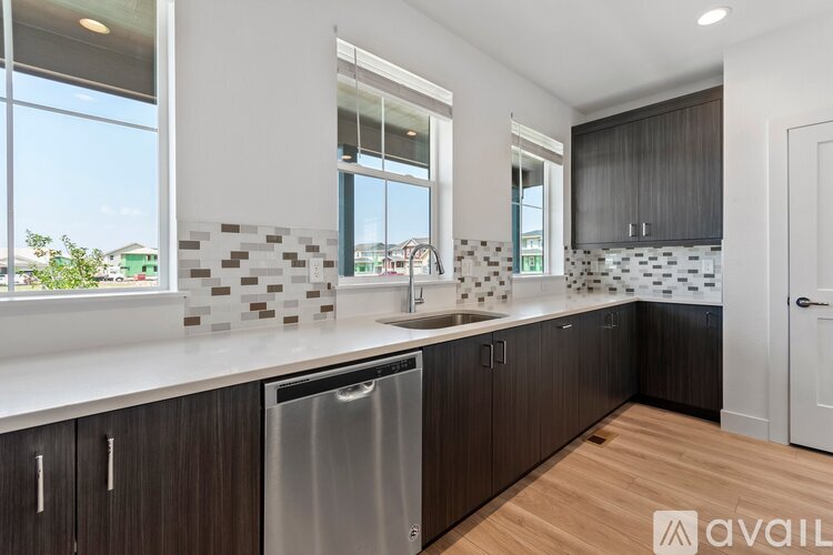 A kitchen with dark wood cabinets and a stainless steel dishwasher.