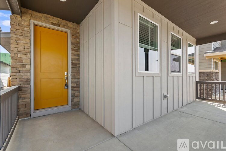 A yellow door is on the left side of a white building.