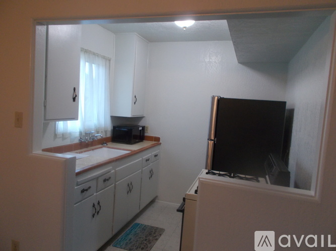 A small kitchen with a TV on the counter.