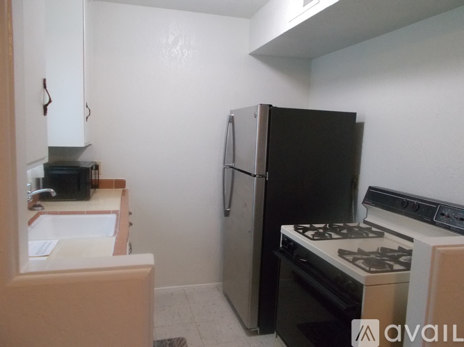 A kitchen with a black fridge, stove, and oven.