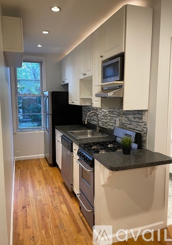 A kitchen with black countertops and white cabinets.