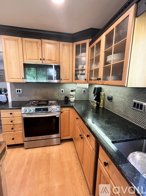 A kitchen with wooden cabinets and a black countertop.