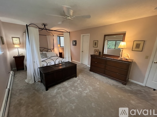 A bedroom with a bed, dresser, and mirror.