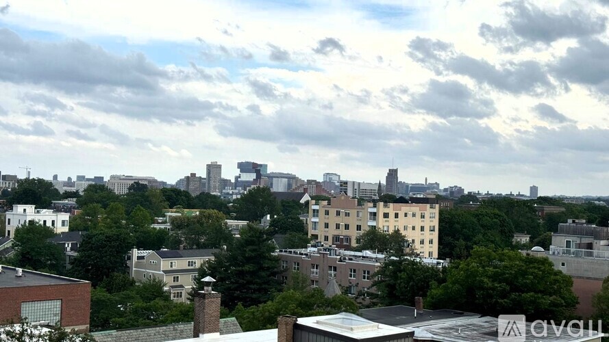 A cityscape with buildings of various heights and a cloudy sky.