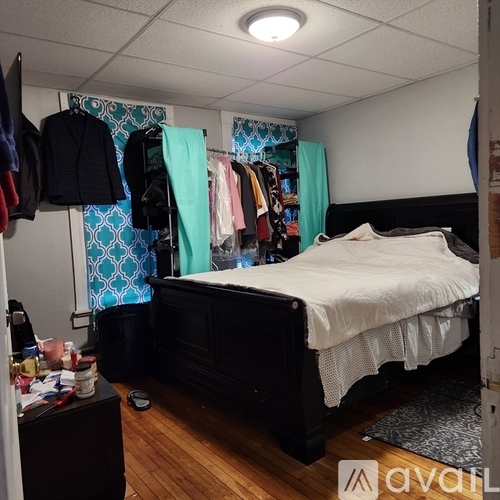A bedroom with a bed, dresser, and closet.