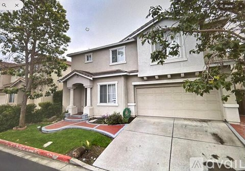 A two-story house with a garage and a tree in front.