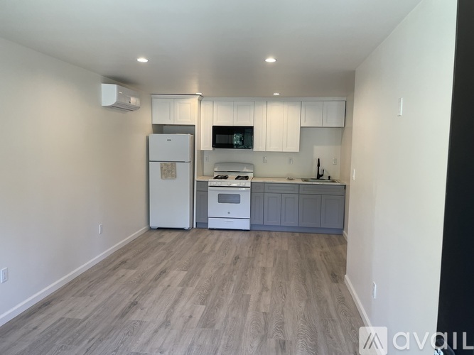 A kitchen with a white fridge, white cabinets, and a white oven.