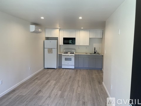 A kitchen with a white fridge, white cabinets, and a white oven.