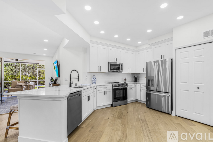 A modern kitchen with white cabinets and stainless steel appliances.