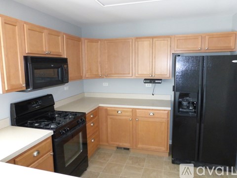 A kitchen with wooden cabinets and black appliances.