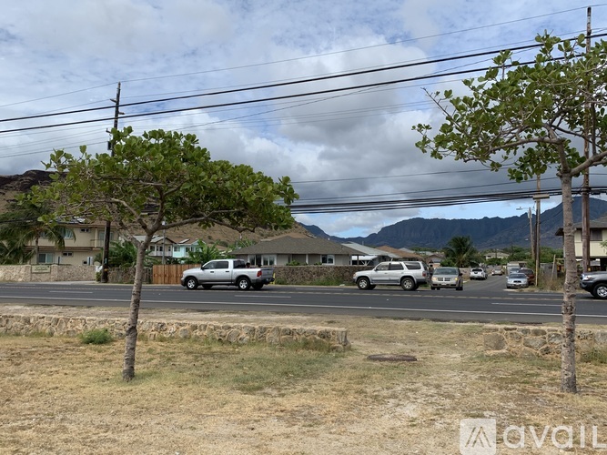 A street view with cars and houses with trees.