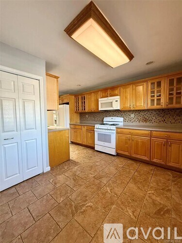 A kitchen with brown cabinets and a white fridge.