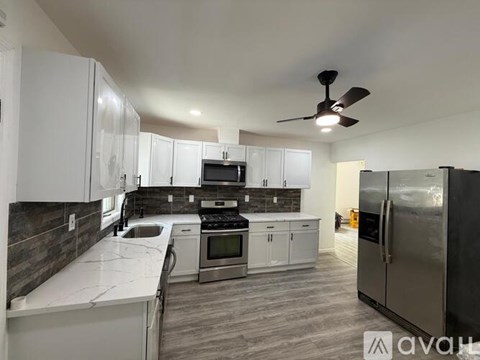 A modern kitchen with white cabinets and stainless steel appliances.