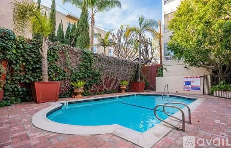 A small pool surrounded by a brick border and a hedge.