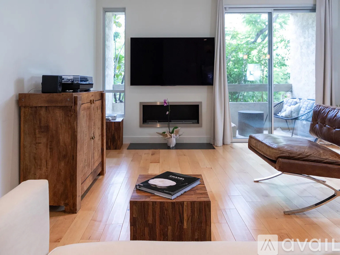 A modern living room with a flat screen TV mounted on the wall above a fireplace.