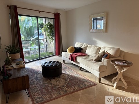 A living room with a white couch and a rug.