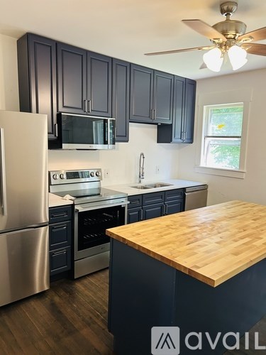 A kitchen with a wooden counter top and stainless steel appliances.