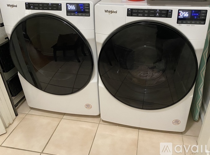Two white Whirlpool washing machines, one with a digital display showing 055 and the other showing 056.