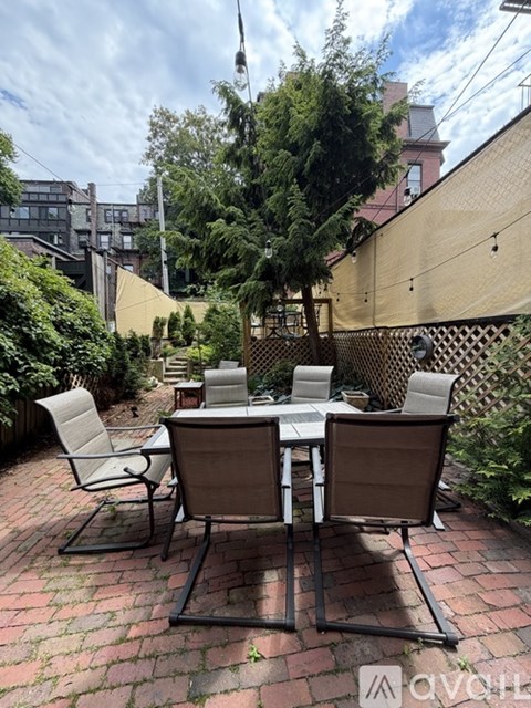 A table with chairs is set up on a brick patio.