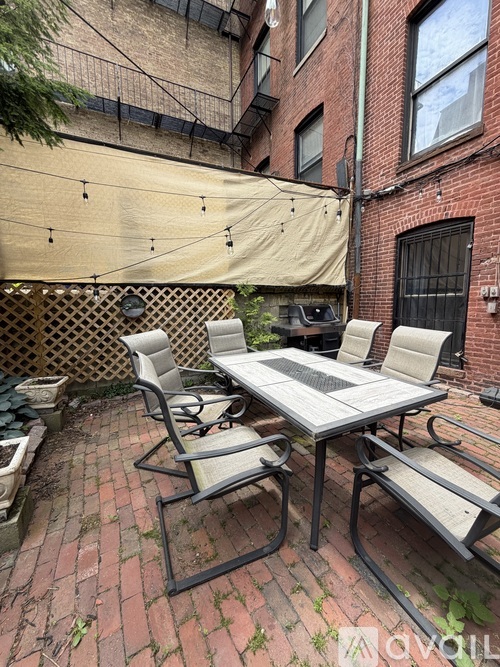 A patio with a table and chairs is covered with a tarp.