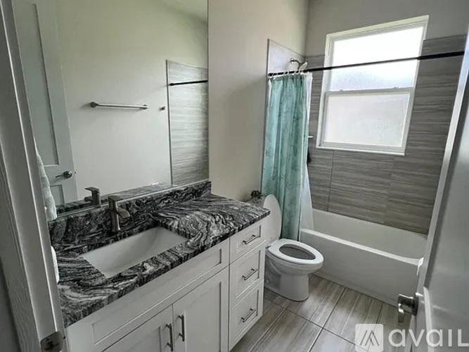A bathroom with a marble countertop and a white toilet.