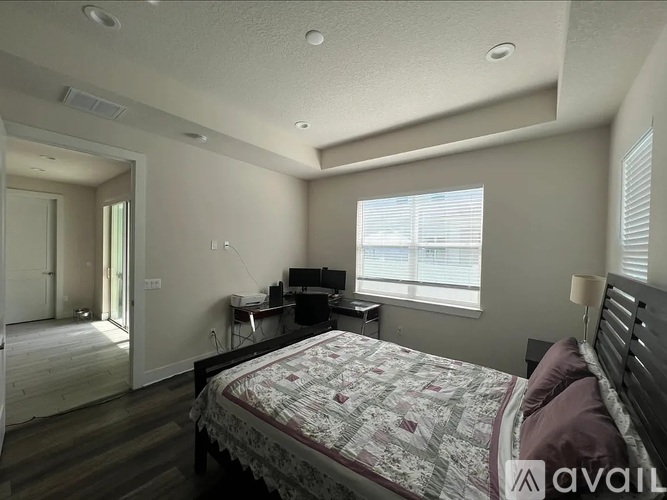 A bedroom with a bed, desk, and chair.