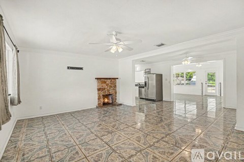 A spacious living room with a fireplace and a tiled floor.